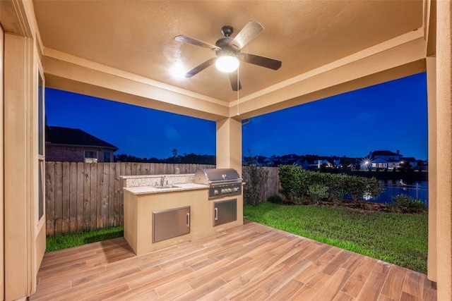 exterior space with a grill, area for grilling, sink, and a water view