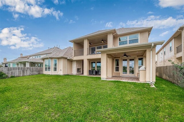 back of house with a lawn, a patio area, ceiling fan, and french doors