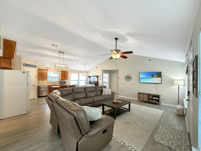 living room featuring light hardwood / wood-style floors, ceiling fan, and lofted ceiling