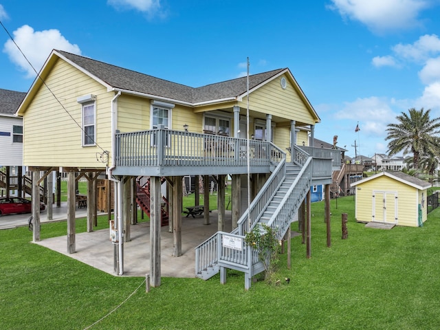 back of house featuring a yard, a patio, a deck, and a storage unit