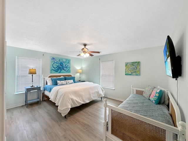 bedroom featuring hardwood / wood-style floors, ceiling fan, and a textured ceiling