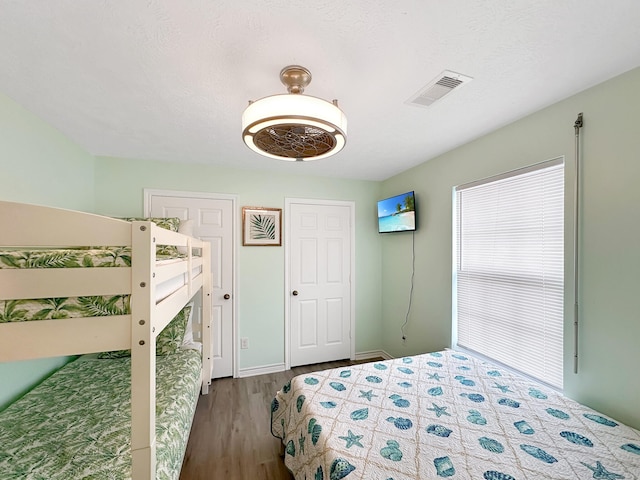 bedroom featuring wood-type flooring, a textured ceiling, and ceiling fan