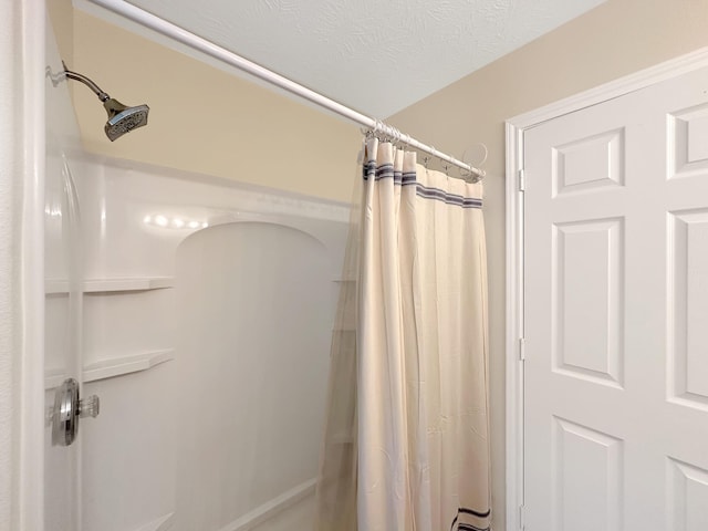 bathroom featuring a shower with curtain and a textured ceiling