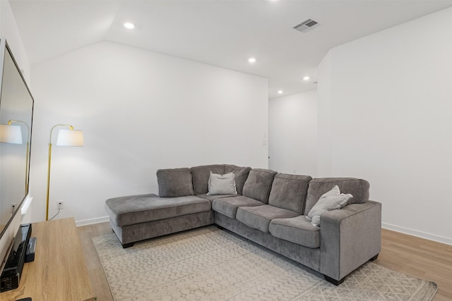 living room featuring light hardwood / wood-style flooring and vaulted ceiling