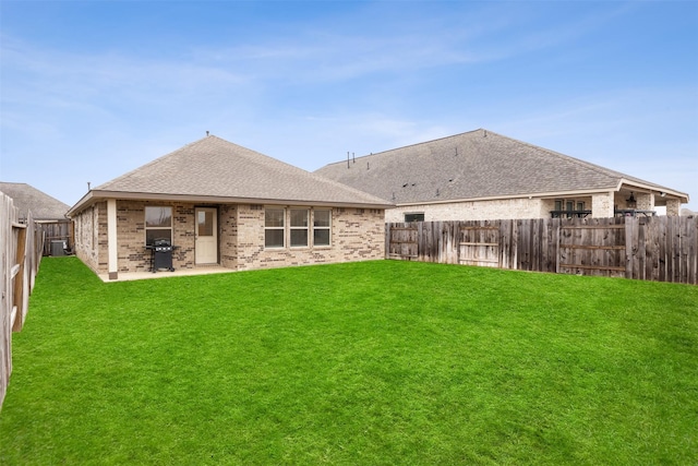 back of house with a lawn and a patio area