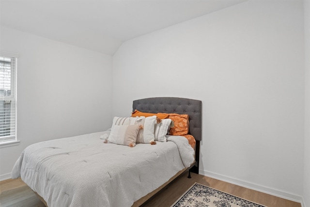 bedroom with light wood-type flooring and lofted ceiling