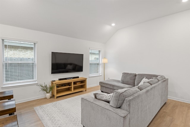 living room with lofted ceiling, hardwood / wood-style flooring, and a healthy amount of sunlight