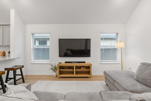 living room featuring light wood-type flooring and vaulted ceiling