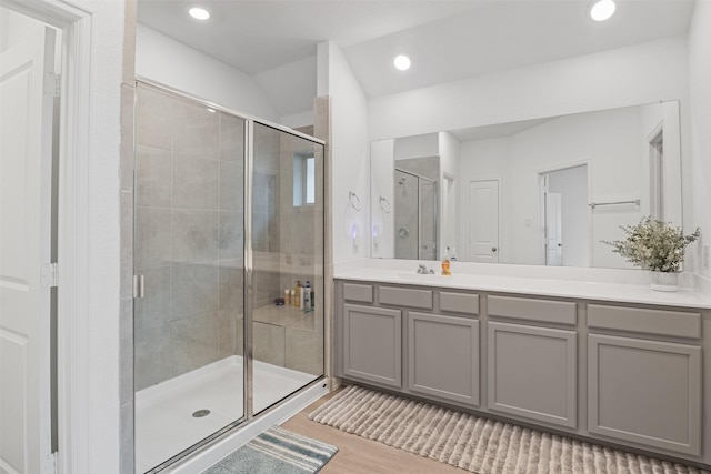 bathroom featuring wood-type flooring, vanity, and walk in shower