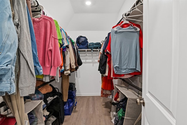 walk in closet with hardwood / wood-style floors and lofted ceiling