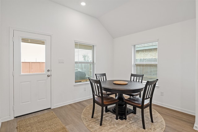 dining area featuring light hardwood / wood-style flooring and vaulted ceiling