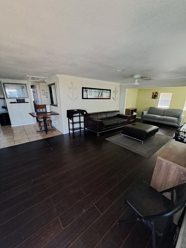 living room featuring hardwood / wood-style flooring, ceiling fan, and a textured ceiling