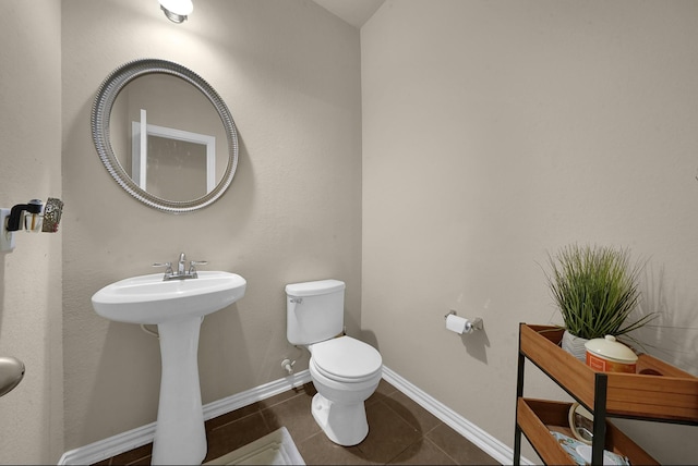 bathroom featuring tile patterned flooring, toilet, and sink