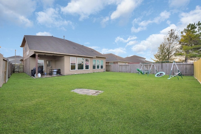 back of house with a playground, a patio area, and a yard