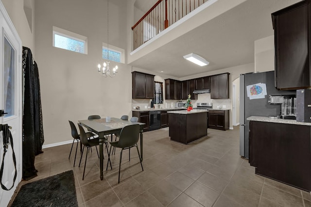 kitchen featuring a center island, tile patterned flooring, a towering ceiling, pendant lighting, and dark brown cabinets