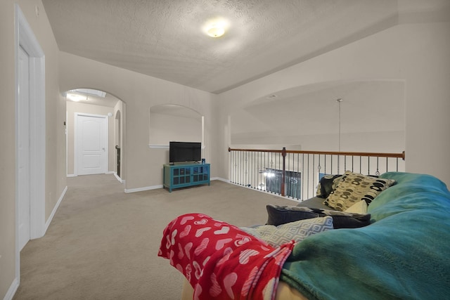 carpeted living room featuring a textured ceiling and vaulted ceiling