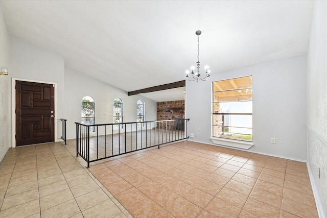 tiled empty room with vaulted ceiling and an inviting chandelier