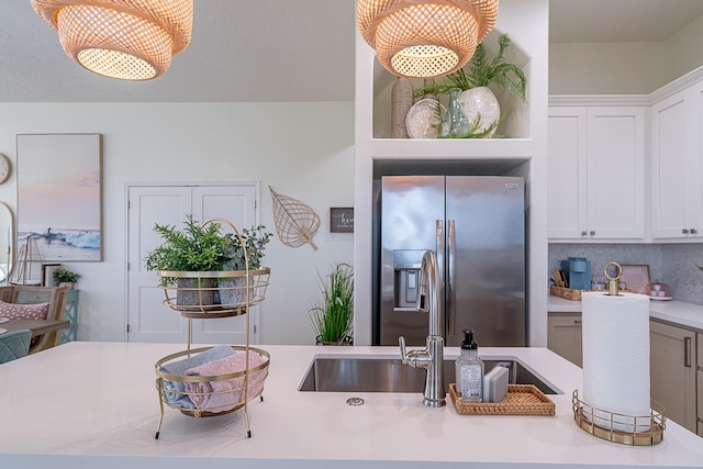 kitchen featuring decorative light fixtures, white cabinetry, stainless steel fridge with ice dispenser, and tasteful backsplash