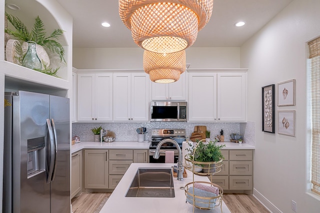 kitchen with decorative backsplash, appliances with stainless steel finishes, an inviting chandelier, and pendant lighting