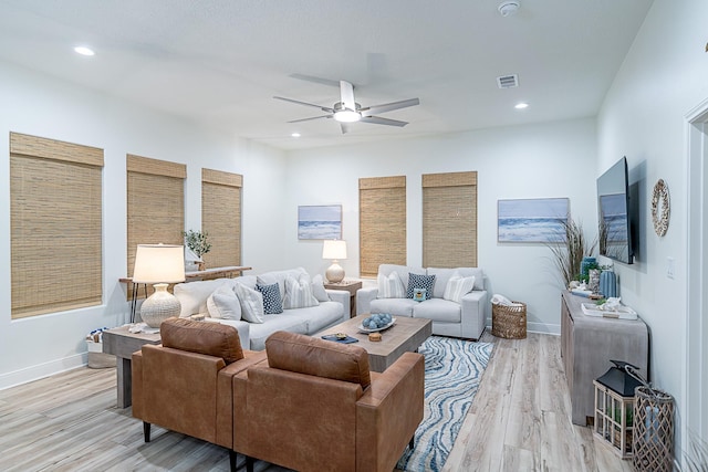 living room featuring ceiling fan and light hardwood / wood-style flooring