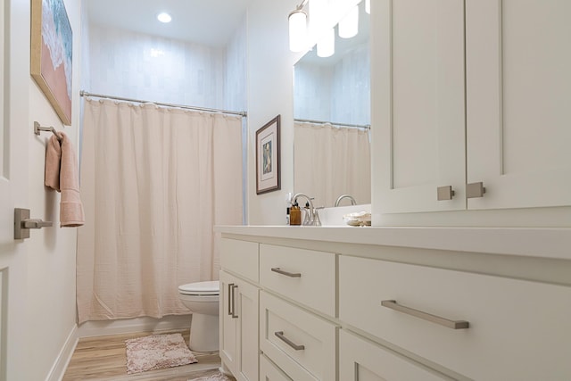 full bathroom with shower / bath combination with curtain, vanity, hardwood / wood-style flooring, and toilet