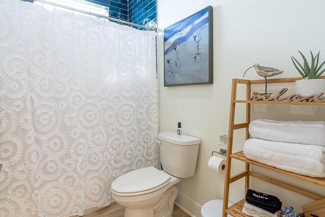 bathroom with walk in shower, wood-type flooring, and toilet