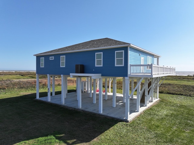 rear view of house with a lawn, a wooden deck, and a patio