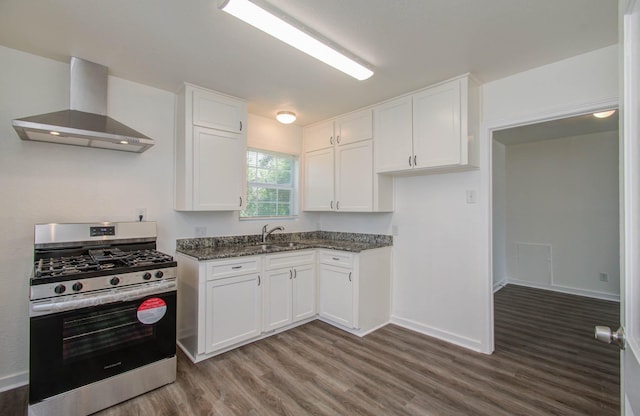 kitchen with gas stove, white cabinetry, wall chimney exhaust hood, and sink