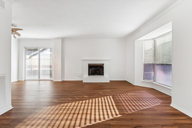 unfurnished living room with dark hardwood / wood-style flooring, crown molding, and a fireplace