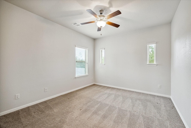 unfurnished room with a healthy amount of sunlight, light colored carpet, and ceiling fan