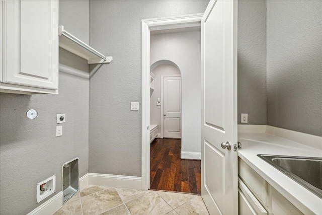 laundry room featuring electric dryer hookup, hookup for a washing machine, cabinets, and sink