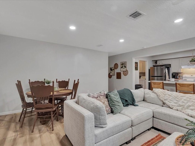 living room featuring light wood-type flooring and washer / clothes dryer