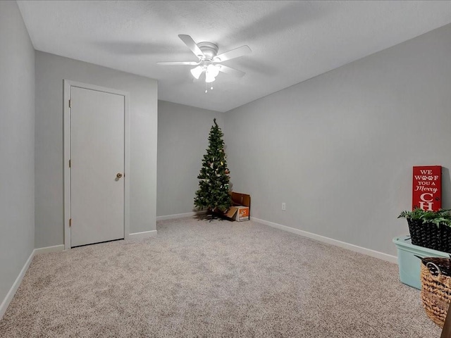 carpeted spare room with ceiling fan