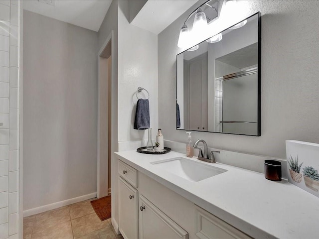 bathroom featuring tile patterned flooring, vanity, and a shower with door