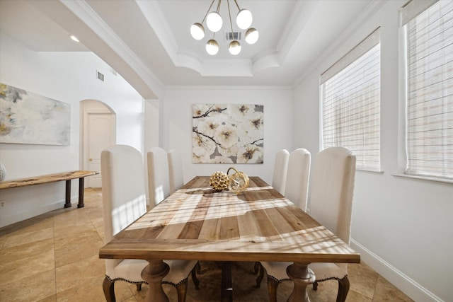 dining room with crown molding, a tray ceiling, and an inviting chandelier