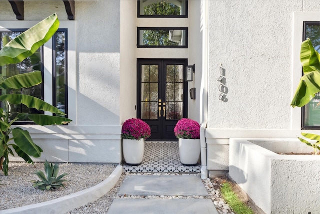 property entrance featuring stucco siding and french doors