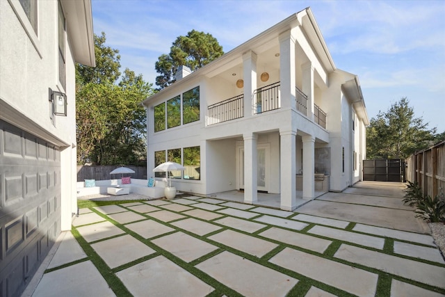 back of house with a balcony and a patio