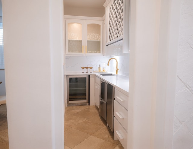 bar with wine cooler, sink, white cabinetry, tasteful backsplash, and light tile patterned floors