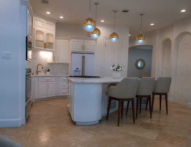 1406 Sue Barnett Dr, Houston, TX 77018 - kitchen featuring built in fridge, white cabinetry, light countertops, a kitchen island, and arched walkways