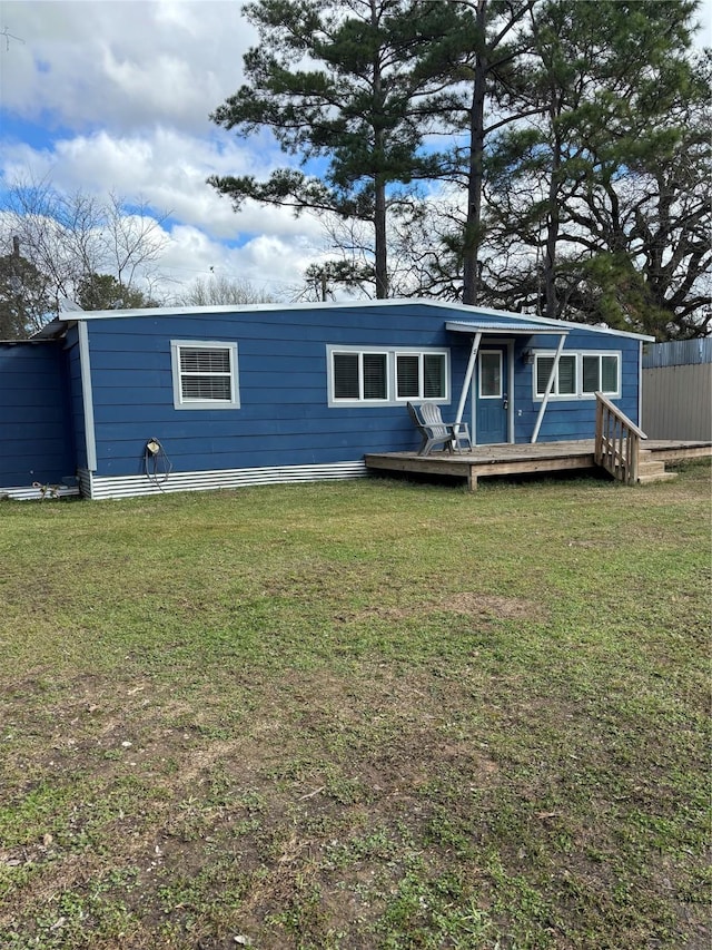 rear view of house with a yard and a deck