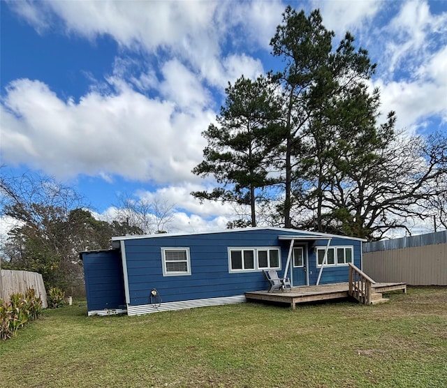 back of property with a wooden deck and a yard