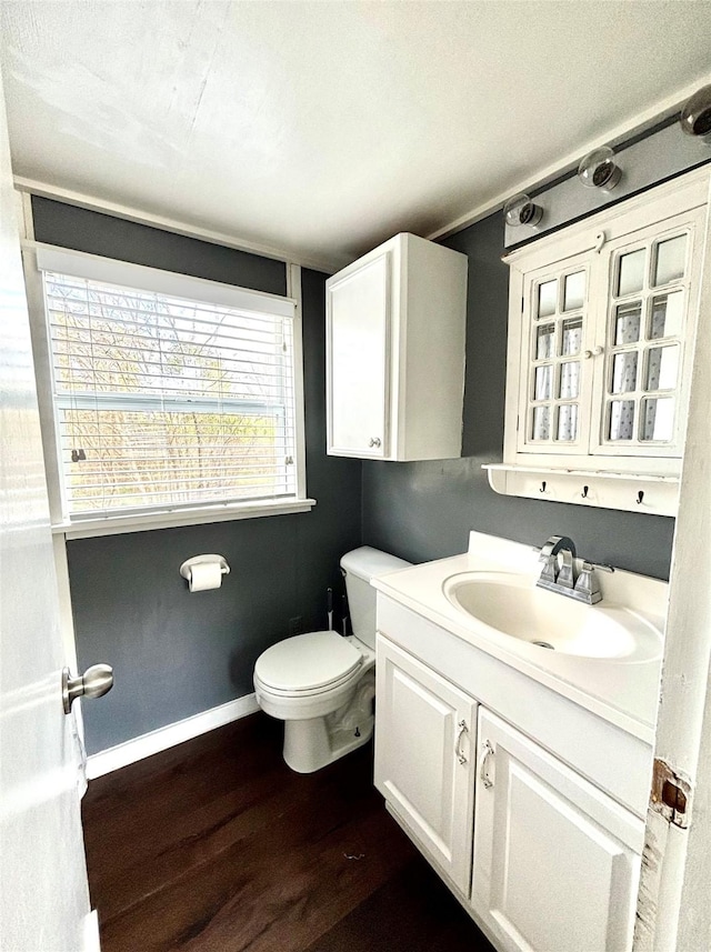 bathroom featuring wood-type flooring, vanity, and toilet