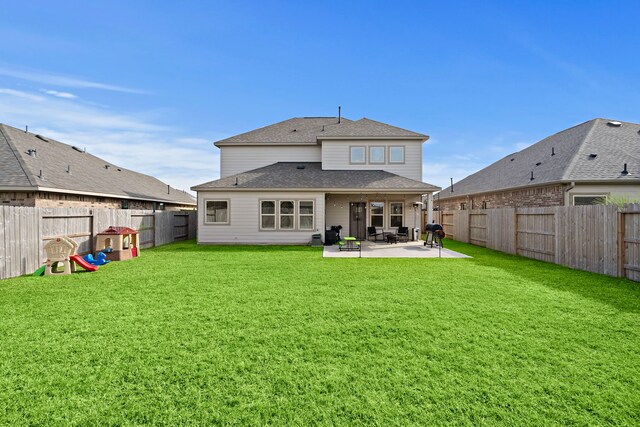 back of house with a patio area and a yard