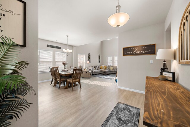 dining room with light hardwood / wood-style floors and an inviting chandelier