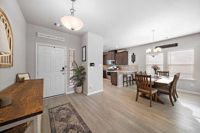 foyer entrance featuring light hardwood / wood-style floors and a chandelier