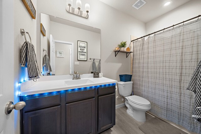 bathroom featuring hardwood / wood-style flooring, vanity, toilet, and a shower with shower curtain