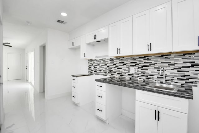 kitchen featuring tasteful backsplash, sink, and white cabinets