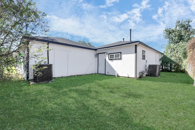 back of property with a lawn and cooling unit