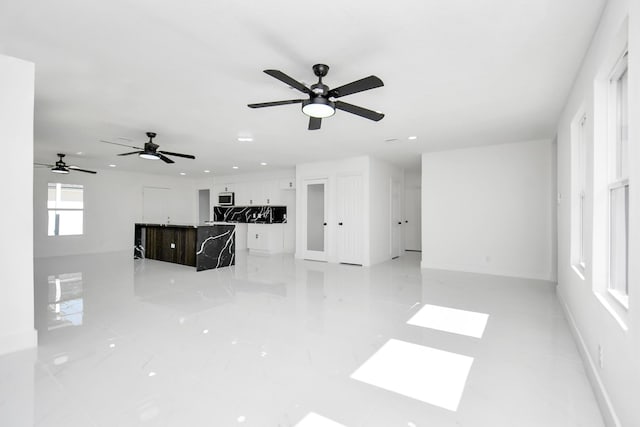 unfurnished living room featuring ceiling fan