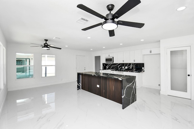 kitchen featuring tasteful backsplash, white cabinetry, and ceiling fan